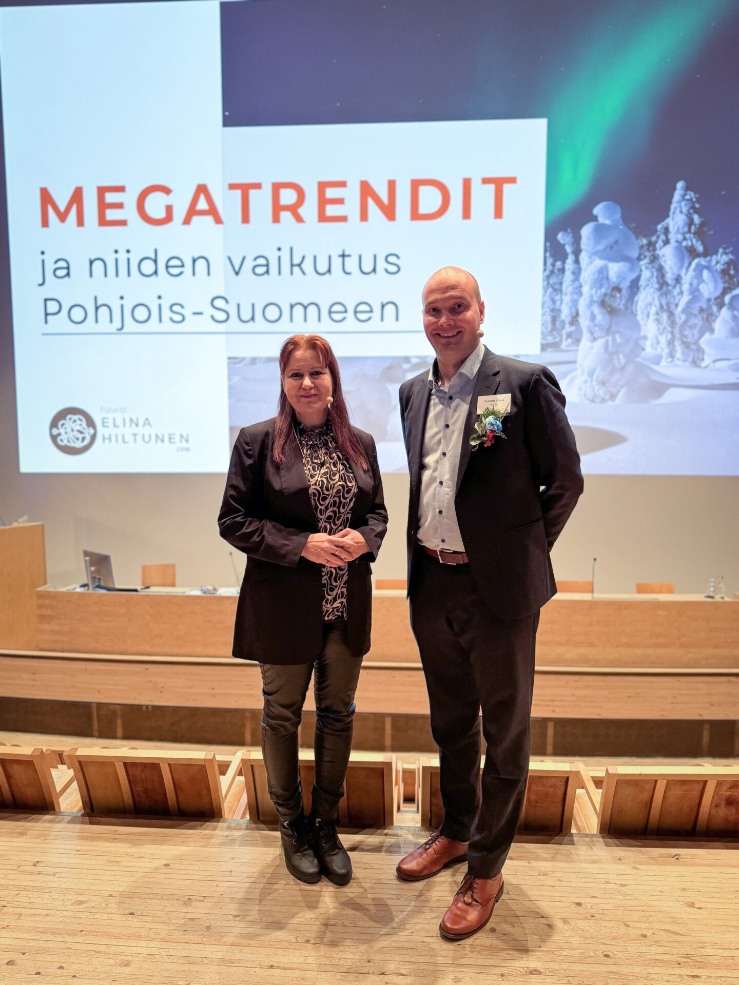 Elina Hiltunen ja Klaus Kianen seisovat kuvan keskellä. Taustalla näkyy seuraava teksti: MEGATRENDIT ja niiden vaikutus Pohjois-Suomeen